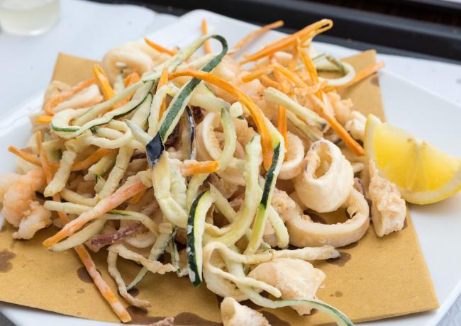 Frittura croccante di calamari e verdure con limone, aroma di mare.