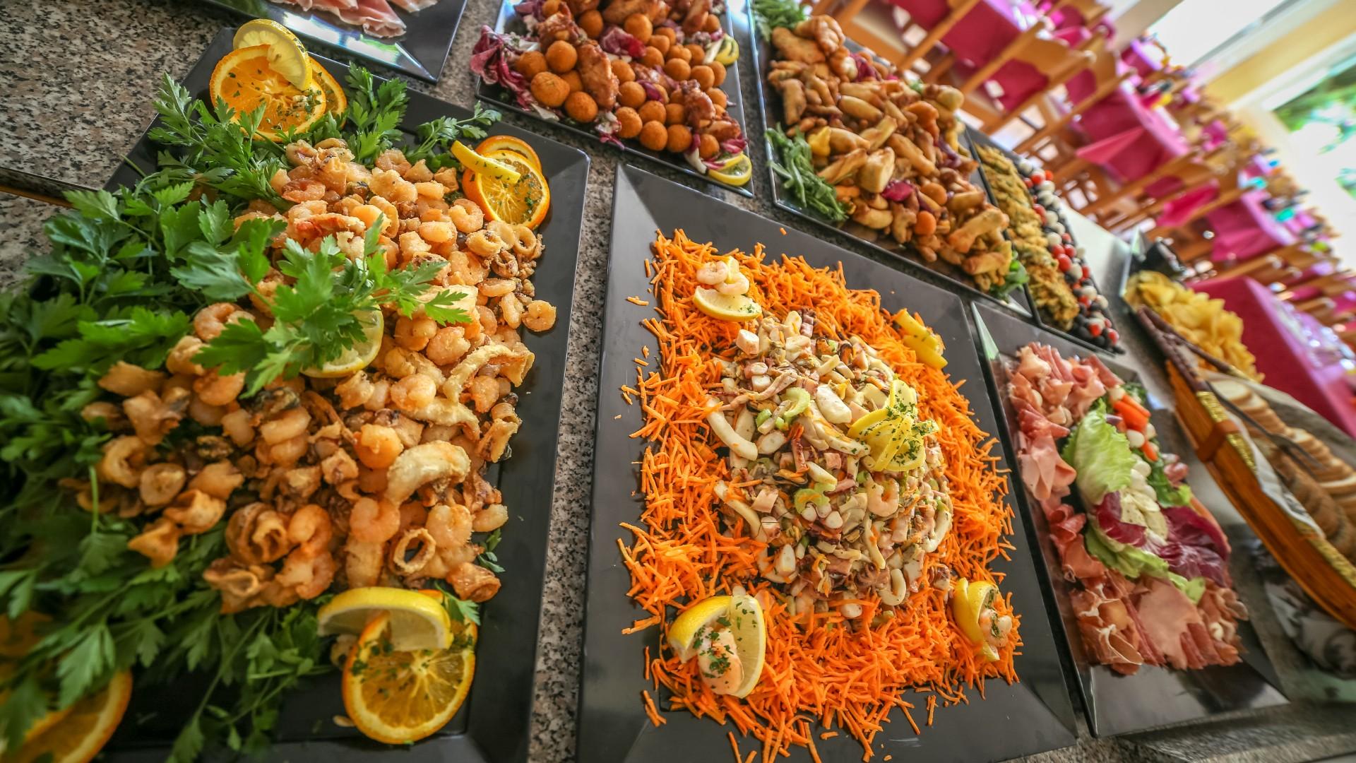 Un ricco buffet di antipasti colorati, con fritti, affettati e insalate, invitante e gustoso.