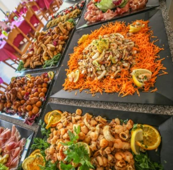 Una tavola ricca di piatti colorati, profumati, pieni di sapori mediterranei e invitanti.